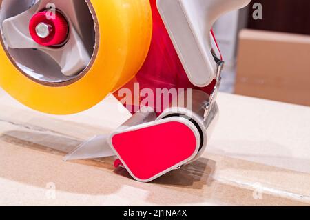 Verpackung von Paketen mit Scotch Tape Dispenser close-up Stockfoto