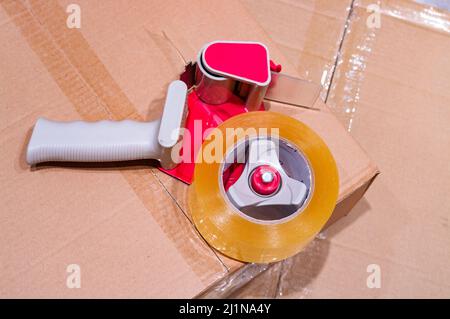 Verpackung von Paketen mit Scotch Tape Dispenser close-up Stockfoto