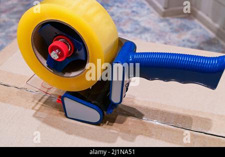 Verpackung von Paketen mit Scotch Tape Dispenser close-up Stockfoto