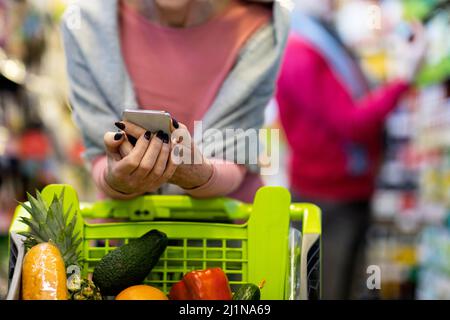 Unkenntliche Kunden Mann und Frau beim Lebensmittelgeschäft im Supermarkt, abgeschnitten Stockfoto
