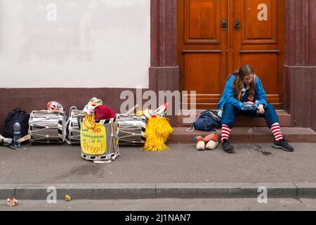 Basel, Schweiz - Februar 21. Alleinstehende Karnevalsnachbarin überprüft ihr Smartphone Stockfoto