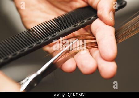 Friseur männliche Hände beim Schneiden weiblicher Haare Stockfoto