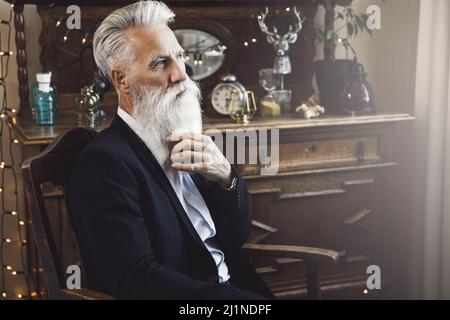 Gutaussehender bärtiger älterer Mann, der im Studio posiert Stockfoto