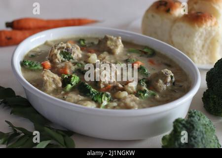 Geschmortes Huhn mit Gemüse. Kerala-Zubereitung mit Karotten, Brokkoli, Kartoffeln, Hühnchen, Kokosmilch und Gewürzen. Aufgenommen auf weißem Hintergrund Stockfoto