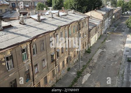 Straßenansicht der Devolanivskyi-Abfahrt (Spusk) in Odesa, Ukraine; die Straße ist unbefestigt und leer; die Häuser sehen alt und heruntergekommen aus Stockfoto