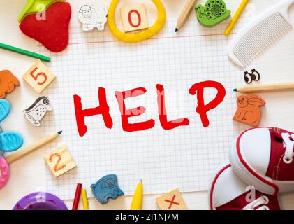 Das Wort Hilfe, geschrieben auf einem Patch. Weiße blanke Baumwolle isoliert auf einer schwarzen Oberfläche. Stockfoto