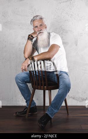 Gutaussehender bärtiger älterer Mann, der im Studio posiert Stockfoto