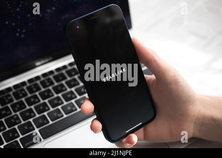 Poltava, Ukraine - 26. März 2022: Starlink-Anwendung mit Logo-Nahaufnahme. Mobiltelefon in der Hand Stockfoto