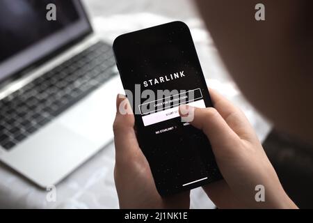 Poltava, Ukraine - 26. März 2022: Person, die Starlink auf dem Smartphone verwendet, Foto aus der Nahaufnahme des Logos Stockfoto