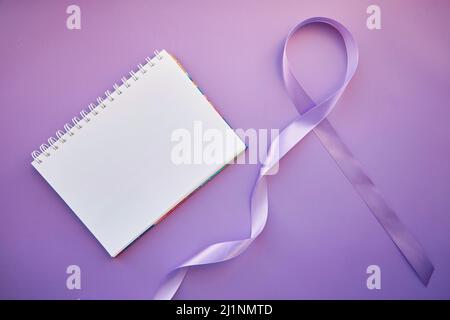 Nachbau von Notizblock und violettem Band für den Purple Day - Welt-Epilepsietag, März 26. Symbol des Epilepsietages. Stockfoto