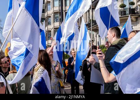 London, 26.. März 2022. Tausende von Menschen treten mit der Ukraine zusammen, marschieren und mahnten im Zentrum von London, um gegen die russische Invasion zu protestieren. Mitglieder der Bewegung gegen den Krieg schließen sich dem marsch an. Die Bewegung hat eine weiße und blaue Flagge als Symbol ihres Protests angenommen, die den roten Streifen der russischen Flagge ersetzt, um die Verbindung mit Blut und Gewalt sowie militärischer Macht und Autoritarismus zu beseitigen. Sie verweist auch auf die historische Flagge von Veliky Nowgorod, wo die Regierung der Republik Nowgorod den Ruf hatte, demokratische Regierungsführung zu entwickeln. Stockfoto