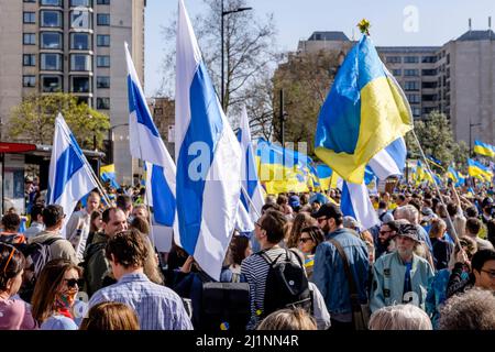 London, 26.. März 2022. Tausende von Menschen treten mit der Ukraine zusammen, marschieren und mahnten im Zentrum von London, um gegen die russische Invasion zu protestieren. Mitglieder der Bewegung gegen den Krieg schließen sich dem marsch an. Die Bewegung hat eine weiße und blaue Flagge als Symbol ihres Protests angenommen, die den roten Streifen der russischen Flagge ersetzt, um die Verbindung mit Blut und Gewalt sowie militärischer Macht und Autoritarismus zu beseitigen. Sie verweist auch auf die historische Flagge von Veliky Nowgorod, wo die Regierung der Republik Nowgorod den Ruf hatte, demokratische Regierungsführung zu entwickeln. Stockfoto