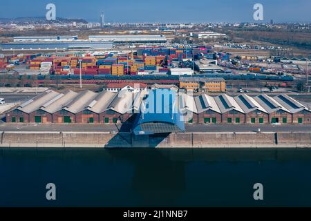 Industriehafen mit Containern in der Donau. Viele Waren warten auf den Versand im Hafen. Stockfoto