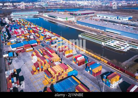 Industriehafen mit Containern in der Donau. Viele Waren warten auf den Versand im Hafen. Stockfoto
