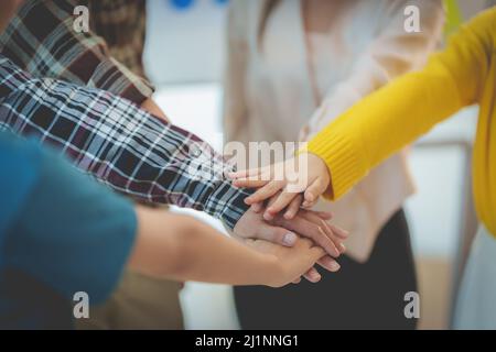 Gruppe von multirassischen Menschen, die ihre Hände zusammenarbeiteten und ein Symbol der Einheit zeigten. Stockfoto
