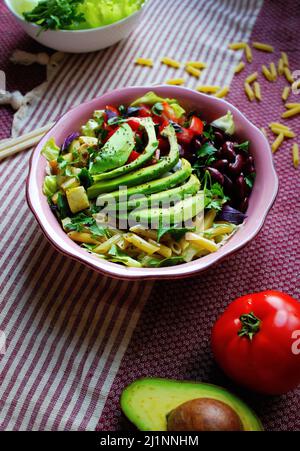 Gesunder Nudelsalat in rosa Schale und Hintergrund Stockfoto
