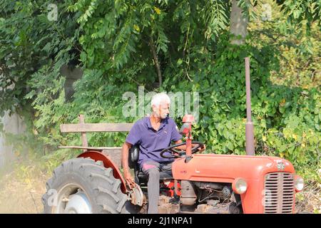 Pali Rajasthan, Indien. November 04 ,2021. Ein indischer älterer Landwirt pflügt das Feld, während er auf einem Traktor sitzt Stockfoto