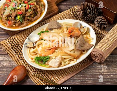 Verschiedene gebratene Nudeln in einem Gericht isoliert auf Matte Seitenansicht auf dunklen Holztisch taiwan Essen Stockfoto