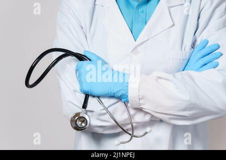 Arzt mit Stethoskop auf grauem Hintergrund Stockfoto