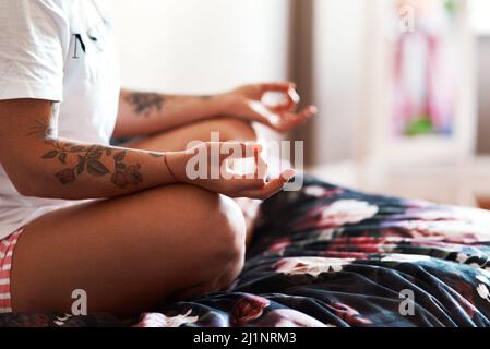 Üben Sie Yoga für Seelenfrieden. Eine kurze Aufnahme einer nicht erkennbaren Frau, die zu Hause Yoga praktiziert. Stockfoto