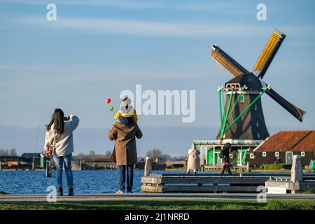 (220327) -- ZAANSE SCHANS, 27. März 2022 (Xinhua) -- Menschen besuchen das Viertel Zaanse Schans in Zaandam, Niederlande, 26. März 2022. Zaanse Schans ist ein Viertel, das vor allem für seine Sammlung gut erhaltener historischer Windmühlen und Häuser in den Niederlanden bekannt ist. (Xinhua/Zhang Cheng) Stockfoto
