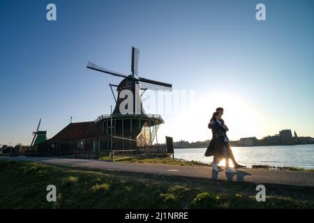 (220327) -- ZAANSE SCHANS, 27. März 2022 (Xinhua) -- Menschen besuchen das Viertel Zaanse Schans in Zaandam, Niederlande, 26. März 2022. Zaanse Schans ist ein Viertel, das vor allem für seine Sammlung gut erhaltener historischer Windmühlen und Häuser in den Niederlanden bekannt ist. (Xinhua/Zhang Cheng) Stockfoto