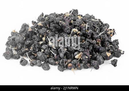 Die schwarzen Wolfbeeren oder schwarzen Goji-Beeren häufen sich auf weißem Hintergrund. Stockfoto