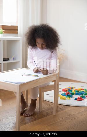 Fokussierte kleine Schüler Mädchen Zeichnung in Buntstiften im Spielzimmer Stockfoto