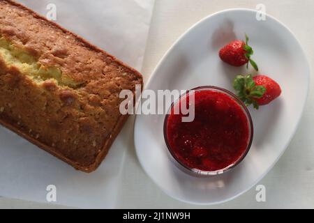Erdbeersoße mit saurer Rahm-Pfund-Kuchen. Aufgenommen auf weißem Hintergrund Stockfoto