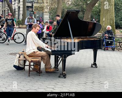 Pianist tritt im Washingtgtgon Square Park in Manhattan auf. Auf seinem Klavier steht geschrieben: „Diese Maschine tötet Faschisten.“ New York City. Stockfoto