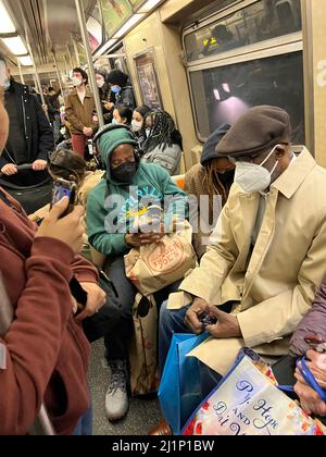 Die U-Bahn-Züge in New York City sind während der Hauptverkehrszeit wieder voll, wo es keine soziale Distanzierung mehr gibt. Im Frühjahr 2022 müssen die Fahrer immer noch Gesichtsmasken tragen. Stockfoto