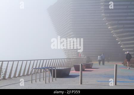 Dundee, Tayside, Schottland, Großbritannien. 27.. März 2022. Wetter in Großbritannien: Aufgrund der kalten Luft aus dem Westen bildet sich über den Fluss Tay dichter Nebel, der atemberaubende Ausblicke über Dundee bietet. Die Temperaturen fielen auf 14 Grad Später am Tag zerstreut die Sonne den Nebel, so dass der warme Sonnenschein scheint und die Temperaturen in Nordostschottland 18 Grad erreichen Spektakuläre Ausblicke von der Dundee-Uferpromenade auf die Tay Road Bridge, den Tay River, die Tay Railway Bridge und das V&A Design Museum im Frühjahr. Kredit: Dundee Photographics/Alamy Live Nachrichten Stockfoto