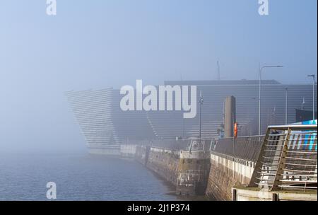 Dundee, Tayside, Schottland, Großbritannien. 27.. März 2022. Wetter in Großbritannien: Aufgrund der kalten Luft aus dem Westen bildet sich über den Fluss Tay dichter Nebel, der atemberaubende Ausblicke über Dundee bietet. Die Temperaturen fielen auf 14 Grad Später am Tag zerstreut die Sonne den Nebel, so dass der warme Sonnenschein scheint und die Temperaturen in Nordostschottland 18 Grad erreichen Spektakuläre Ausblicke von der Dundee-Uferpromenade auf die Tay Road Bridge, den Tay River, die Tay Railway Bridge und das V&A Design Museum im Frühjahr. Kredit: Dundee Photographics/Alamy Live Nachrichten Stockfoto