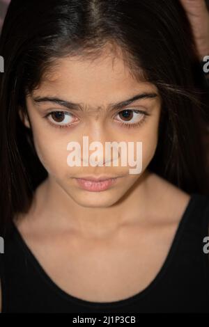 Ein Indermädchen im Schulalter posiert, schaut in die Kamera. Stockfoto