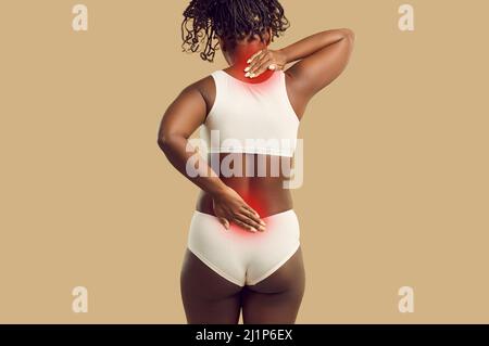 Schwarze Frau, die an Rückenschmerzen leidet, berührt schmerzhafte Nacken- und Unterrückenbereiche Stockfoto