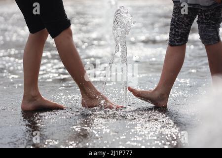 Aschersleben, Deutschland. 27. März 2022. Eine Wasserfontäne sorgt für Erfrischung in einem Stadtpark in Herrenbreite. Bei strahlendem Sonnenschein und warmen Temperaturen konnten viele Besucher den Frühling genießen. Quelle: Matthias Bein/dpa-Zentralbild/ZB/dpa/Alamy Live News Stockfoto