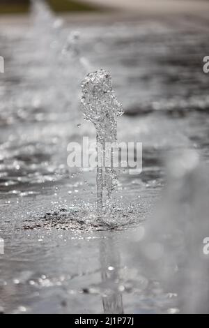 Aschersleben, Deutschland. 27. März 2022. Eine Wasserfontäne sorgt für Erfrischung in einem Stadtpark in Herrenbreite. Bei strahlendem Sonnenschein und warmen Temperaturen konnten viele Besucher den Frühling genießen. Quelle: Matthias Bein/dpa-Zentralbild/ZB/dpa/Alamy Live News Stockfoto