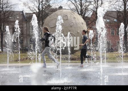 Aschersleben, Deutschland. 27. März 2022. Ein Wasserbrunnen vor einer Nachbildung des Mondes sorgt für Erfrischung in einem Stadtpark in Herrenbreite. Bei strahlendem Sonnenschein und warmen Temperaturen konnten viele Besucher den Frühling genießen. Quelle: Matthias Bein/dpa-Zentralbild/ZB/dpa/Alamy Live News Stockfoto