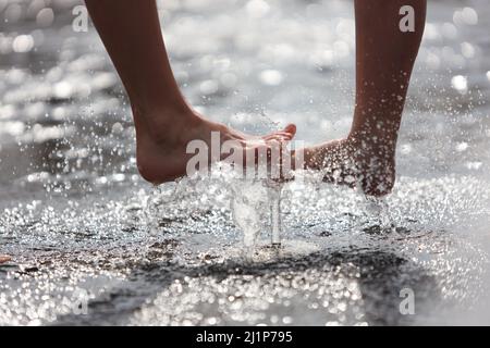 Aschersleben, Deutschland. 27. März 2022. Eine Wasserfontäne sorgt für Erfrischung in einem Stadtpark in Herrenbreite. Bei strahlendem Sonnenschein und warmen Temperaturen konnten viele Besucher den Frühling genießen. Quelle: Matthias Bein/dpa-Zentralbild/ZB/dpa/Alamy Live News Stockfoto