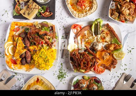 Verschiedene arabische und nahöstliche Gerichte auf weißem Hintergrund. Hummus, Metabal, Fattoush-Salat, Falafel. Draufsicht Stockfoto