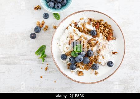 Schüssel Müsli mit frischer Heidelbeere, Quark oder Quark, Joghurt und Nüssen. Gesunde Ernährung. Frühstück. Draufsicht Stockfoto