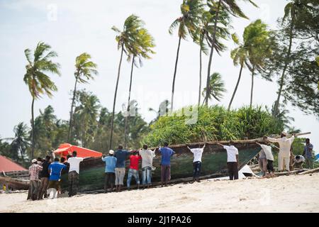 Sansibar City, Tansania-Januar 02,2019: Einheimische Fischer reparieren ihre Boote am Strand der Insel Sansibar. Stockfoto