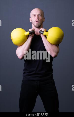 Typ mit einer gelben Kettlebell Turnhalle anonyme gelbe Stärke, aus fit Anstrengung für lackiert und Gummi Sportbekleidung, Südosten filipino. Lebensintervall Stockfoto