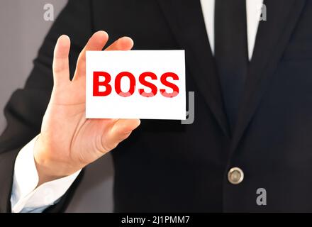 Geschäftsmann zeigt eine Karte mit dem Wort BOSS. Geschäftskonzept des CEO oder General Managers Stockfoto