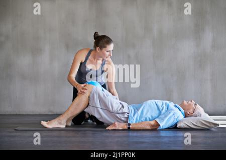 Ihre Patienten dabei zu unterstützen, stark und gesund zu bleiben. Aufnahme eines Physiotherapeuten, der mit einem älteren Mann arbeitet. Stockfoto