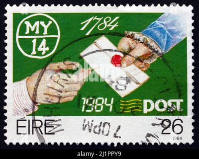 IRLAND - UM 1984: Eine in Irland gedruckte Briefmarke zeigt die Abgabe eines versiegelten Briefes, Zweihundertjahrfeier der Post, um 1984 Stockfoto