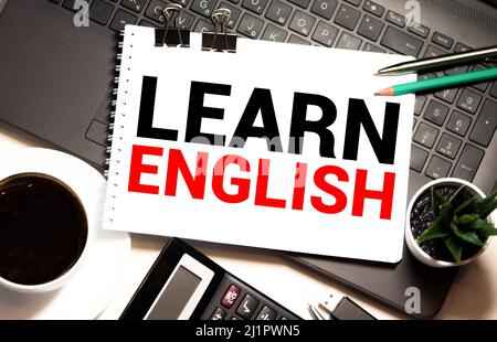 Englisch lernen Text geschrieben auf Notizbuchseite, rotem Bleistift und Kaffeetasse. Blick von oben auf den Schreibtisch Stockfoto
