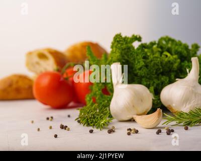 Nützliche Produkte, Vitamine auf weißem Hintergrund - Knoblauch, Tomaten, Kräuter, Baguette. Kochen, Salat Zutaten. Gesunde Lebensweise, Ernährung, Bio-Lebensmittel Stockfoto