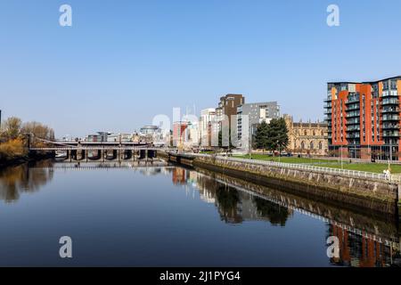 Blick nach Westen entlang des Flusses Clyde zur Hängebrücke der South Portland Street mit der Victoria Bridge dahinter und dem Broomielaw-Gehweg Stockfoto
