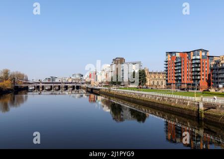 Blick nach Westen entlang des Flusses Clyde zur Hängebrücke der South Portland Street mit der Victoria Bridge dahinter und dem Broomielaw-Gehweg Stockfoto